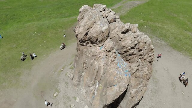 Aerial view of Taikhar Rock rising from flat grassland plain sacred tourism landmark in Mongolia. Granite monolith marks ritual heritage, pilgrimage appeal, steppe symbolism, cultural destination.