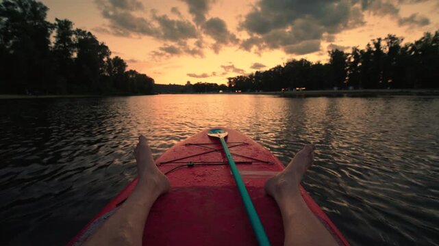 Feet on Paddleboard POV at Sunset: Relaxing on Water with Legs Stretched Out | First Person View of Calm Lake or River | Peaceful Summer Evening Recreation