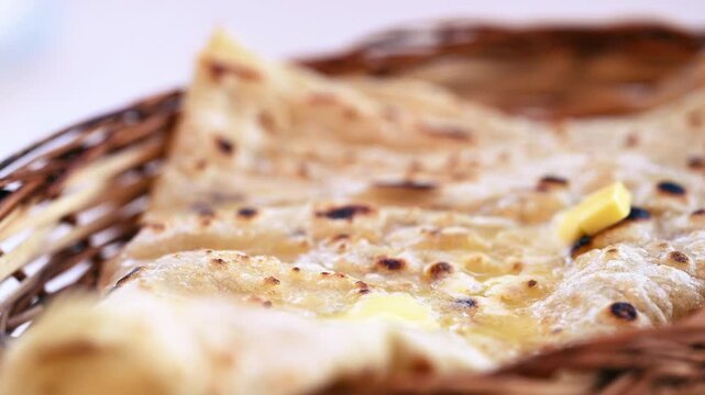 Naan bread on dark background close-up. Paratha and roti. Indian bread 4K video. Chapati and butter naan.