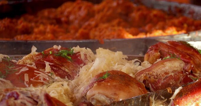 Roasted pork knuckle with stewed sauerkraut steaming at street food market