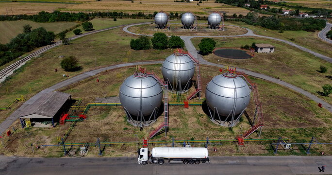 Aerial view of spherical industrial gas storage tanks at a facility with a tanker truck parked on the road in Belgrade, City of Belgrade, Serbia.