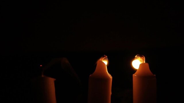 Three Glowing Candles Burning Brightly and Being Extinguished in a Calm Atmospheric Scene