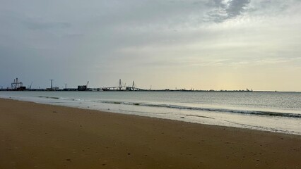 Beach in El Puerto de Santa Maria with Constitution Bridge and Cadiz port in background, Spain © Salud
