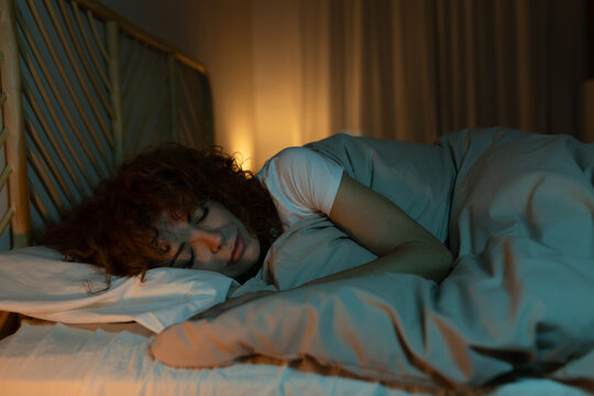 Woman sleeping peacefully in bed at night
