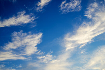 Fototapeta premium weightless white cirrus clouds scattered across a deep blue sky on a clear sunny day