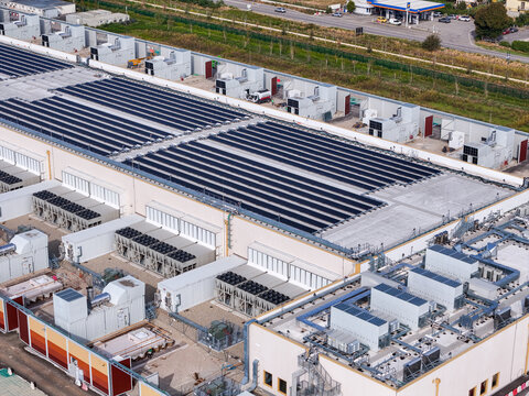 Aerial view of the Noviglio Data Center, a large technology campus featuring extensive rooftop solar panels and industrial cooling infrastructure in Noviglio, Lombardy, Italy.
