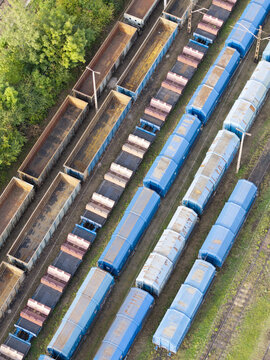 Aerial view of specialized freight wagons and steel cargo loaded on train cars parked on parallel tracks in Poland.