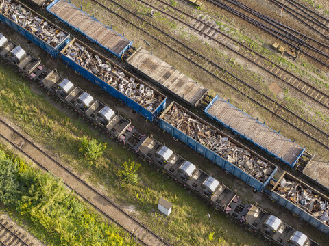 Aerial view of freight train wagons loaded with steel coils and scrap metal on railway tracks in Poland.
