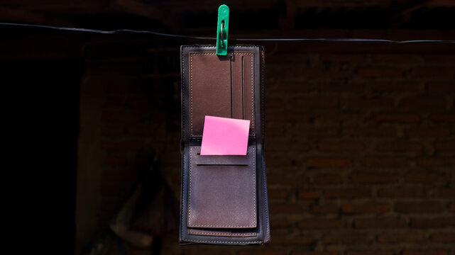 Empty Wallet Hanging with Blank Sticky Note Concept