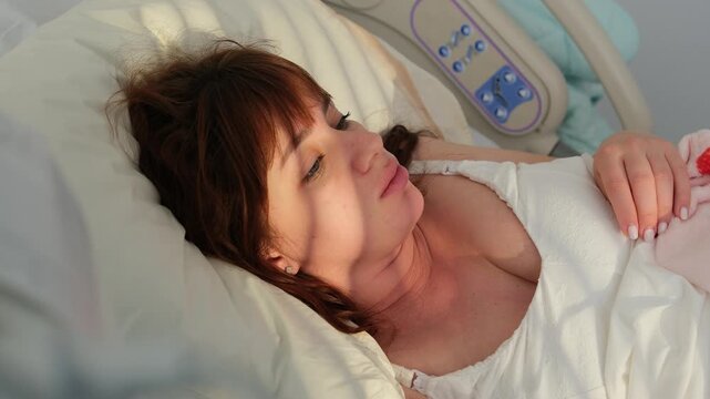 Pregnant woman lying in a hospital bed, preparing for childbirth and resting between contractions. High-angle view of a future mother patiently waiting for her baby's arrival in a medical setting