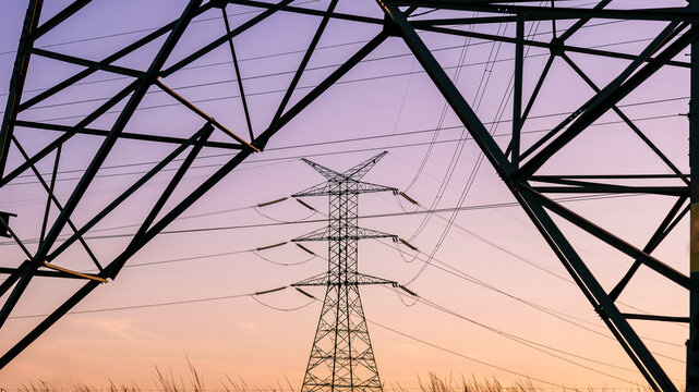 High voltage transmission towers at sunset.
