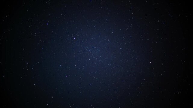 Timelapse of a starry night sky with a faint satellite trail