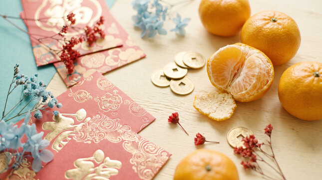 chinese new year red envelopes and mandarins with lucky coins