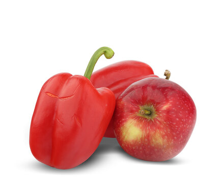 two red bell peppers next to an apple