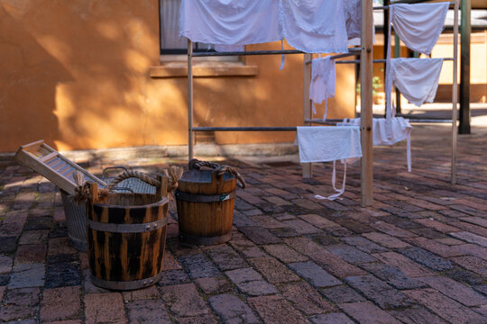 Historical laundry display with wooden buckets, washboard, and drying rack