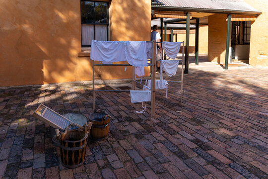 Historical laundry display with wooden buckets, washboard, and drying rack