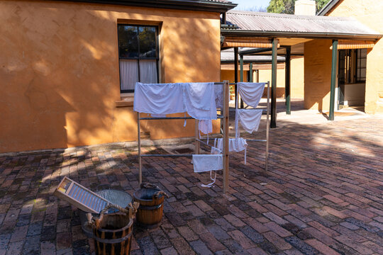 Historical laundry display with wooden buckets, washboard, and drying rack