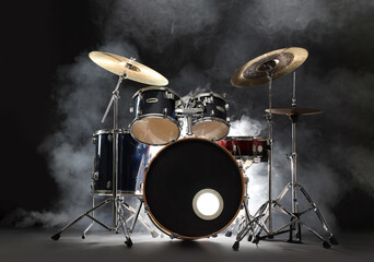Fototapeta premium Drum set on black background with smoke. Musical instrument