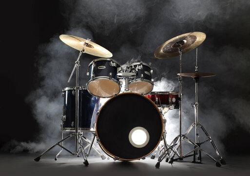 Drum set on black background with smoke. Musical instrument