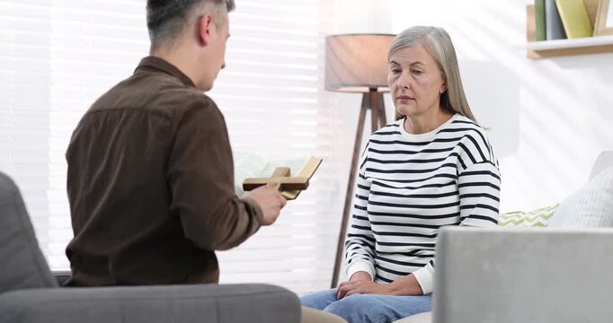 Pastor conducting Bible study with senior woman at home