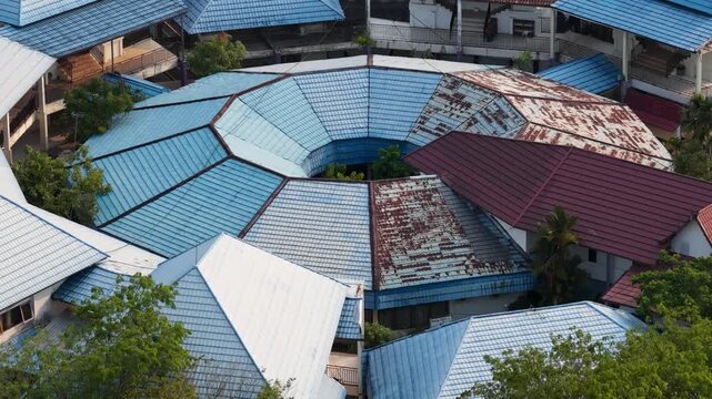 Circular building architecture with weathered blue metal roofs seen from an aerial perspective