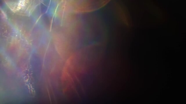 Dreamy bokeh of reflective shimmer with a dazzling shine and gleam of rainbow lens rays. Shining reflections creating visual of magical glittering lights and a glowing aura of iridescent colors. Loop
