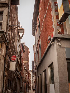 Rue de la wache, a dark pedestrian decaying street of the city center of Liege, belgium, with facade of old buildings ready to be renovated in a real estate operation.