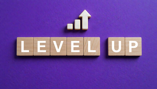 Modern wooden blocks spelling Level Up with upward growth chart on purple background