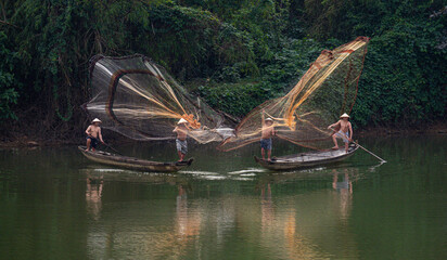 Throwing a fishing net on Nhu Y river, Hue, Vietnam. This is a river flowing through Hue city, where many Hue fishermen live.  © huong