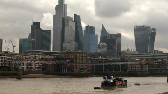 London city skyline featuring modern skyscrapers and river thames view with barge.