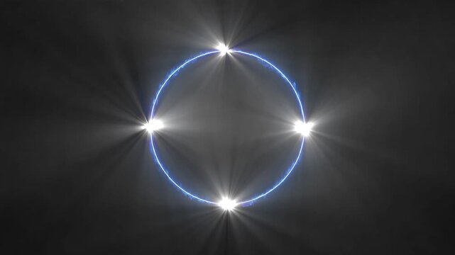 A bright blue circular neon ring with four intense white starbursts at cardinal points set against a smoky dark gray background with subtle light rays and atmospheric haze Keywords: blue, neon