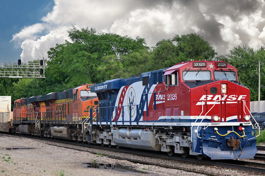 After heavy thunderstorms raced through the area, locomotives, including a specially painted unit honoring America's 250th anniversary, led a Burlington Northern Santa Fe stack train out from Chicago.