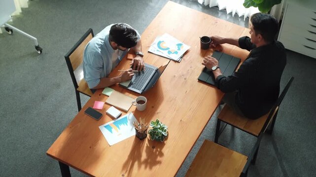 Top view of caucasian businessman walking and stared work at meeting room. Business team working together to analysis financial graph at table with sticky note and document placed on it. Convocation.