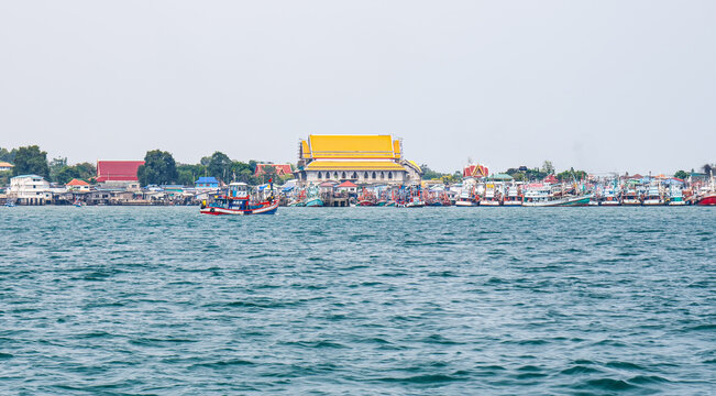 Fishing Boats and Coastal Village at Chong Samaesan Chon Buri Thailand. fishing boats line the waterfront near Thai temple at Chong Samaesan Village, Sattahip, showcasing coastal community and culture
