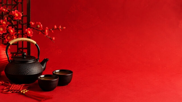 Traditional Chinese Tea Set with Black Teapot and Cups on Red Background