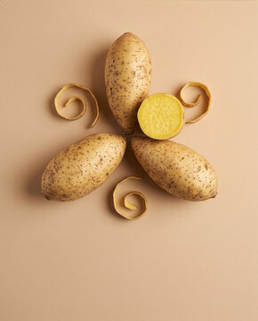 Yellow Sweet Potato Halved Showing Golden Flesh, Raw Ubi Kuning Root Vegetable on Beige Studio Background