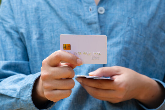 Close up of hand human holding multiple color credit cards, choosing a red card for payment, concept of consumerism, financial management, debt and cashless society and saving money	