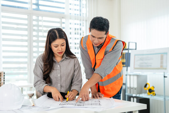 Engineer team working with drawings inspection at desk in site office .Engineering tools and construction concept.