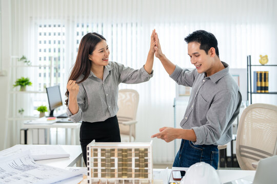 Win. emotional excited business engineer team celebrating success, raising and  clenched fists  at modern office using laptop, reading great news screaming yes.