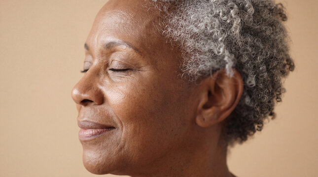 National Healthy Skin Month elegant profile of a serene senior Black woman with silver hair and glowing skin for ageless beauty features.