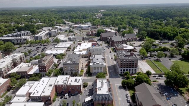 Aerial view of a small historic town in the american south with lush green trees and traditional brick architecture.