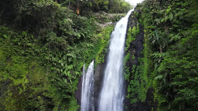 Aerial Footage of Gomblang Waterfall Flowing Through a Tropical Forest with Pristine Water, Wild Trees, and Large Rocks During Morning in Indonesia. The Scenic Cascade and Dense Wilderness from Above.