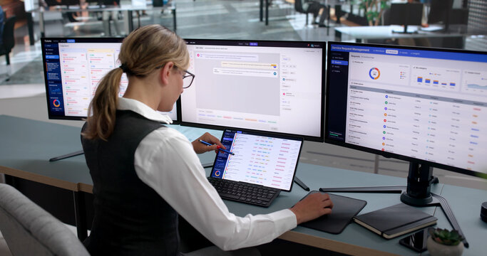 Young Woman Using Laptop To Track IT Support Tickets