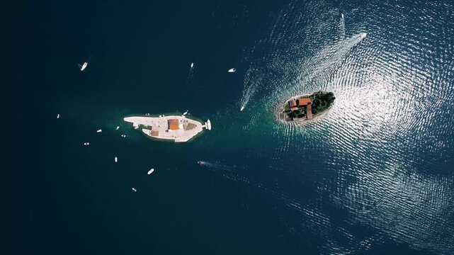 Breathtaking drone perspective reveals elegant yacht gliding towards remote islet amidst vibrant ocean environment