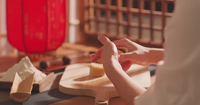Brushing egg liquid on handmade mooncake for Mid‑Autumn Festival