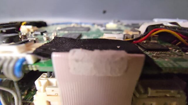 Side angle macro camera pan showing green printed circuit board edge with wire bundle, connectors, and flat ribbon cable setup.
