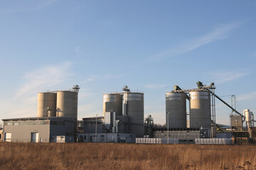 Industrial Grain Silos and Processing Plant Under Blue Sky © 靠谱 不