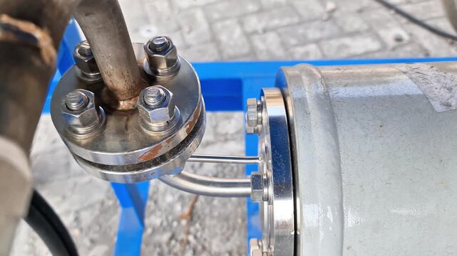 Close-Up of Stainless Steel Industrial Pipe Flange Connection with Bolts, Gasket Seal and Instrumentation Tubing