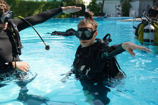 Professional scuba diver instructs the novice how to use the equipment before dive