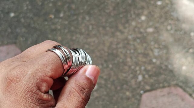 Person Holding Metal Keyrings Inserted Over Fingers Close Up
